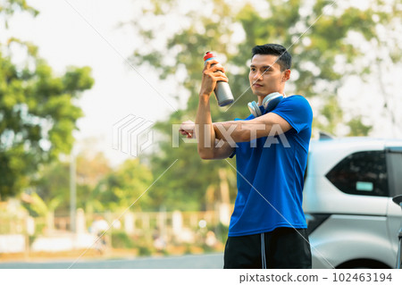 Athletic man resting after workout session and stretching arms. Fitness, training and healthy lifestyle concept Athletic man resting after workout session and stretching arms. Fitness, training and healthy lifestyle concept 102463194