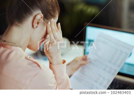 Seen from behind modern business woman having headache Seen from behind modern business woman having headache 102463403