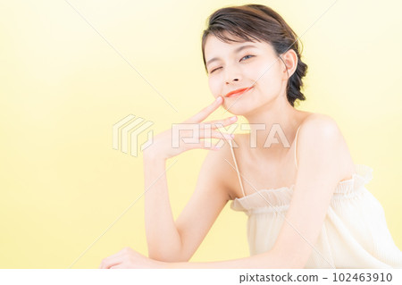 Young woman doing skin care with yellow back 102463910