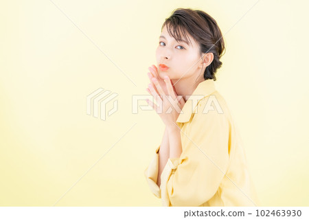 年輕女子穿著時髦的衣服在黃色背景下擺姿勢 102463930