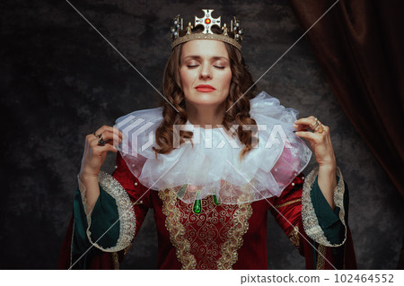 medieval queen in red dress with white collar and crown 102464552