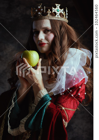 medieval queen in red dress with green apple and white collar 102464560