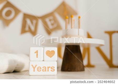 Wooden cubes, a perpetual calendar with one year. Photo zone of the celebration of the first year of the baby with a copy space Wooden cubes, a perpetual calendar with one year. Photo zone of the celebration of the first year of the baby with a copy space 102464602