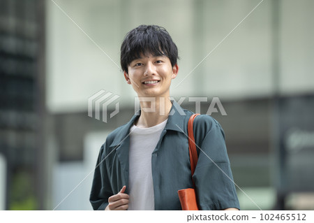 A man in his twenties smiling at the camera A man in his twenties smiling at the camera 102465512