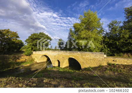 Romanesque bridge of Artigue and river Osse near Larressingle on route to Santiago de Compostela, UNESCO World Heritage Site, departement Gers, France 102466102