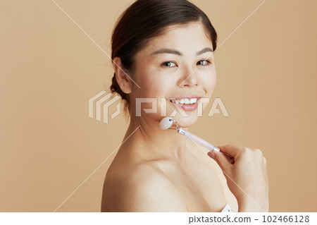 Portrait of modern asian woman with roller massager 102466128