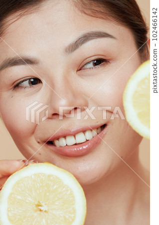 young woman with lemon on beige background young woman with lemon on beige background 102466142