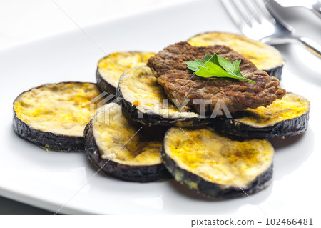 meat in breadcrumbs with grilled aubergine 102466481