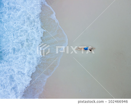 overhead view of woman in blue swimsuit at sea beach overhead view of woman in blue swimsuit at sea beach 102466946