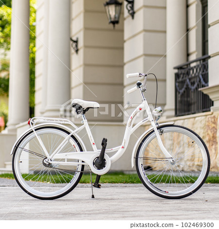 View of urban city bicycle parked on street in neighborhood. Sun bike summer. No people. 102469300