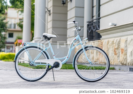 Side view of a modern city urban city bike or bicycle for street road. City bicycle parked on a lawn. Urban bike standing upright on grass, static, no people. 102469319