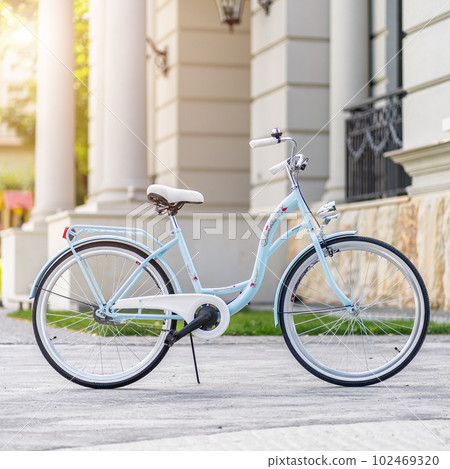 Side view of a modern city urban city bike or bicycle for street road. City bicycle parked on a lawn. Urban bike standing upright on grass, static, no people. 102469320
