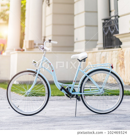 Side view of a modern city urban city bike or bicycle for street road. City bicycle parked on a lawn. Urban bike standing upright on grass, static, no people. 102469324