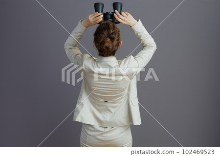 trendy female worker in light business suit looking up 102469523