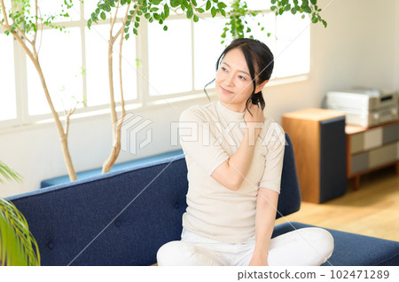 Middle-aged woman rubbing her shoulder Middle-aged woman rubbing her shoulder 102471289