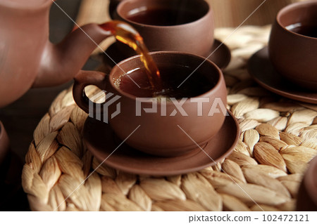 Tea Ceremony. Traditional Asian Tea Utensil, Serving Authentic Set. Person Pouring Tea from Brown Pottery Teapot to Teacup. Bamboo Tray. Lifestyle. Wellness Balance Health. Tea Brewing Equipment 102472121