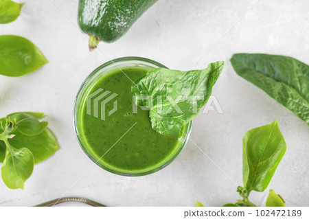 Healthy green smoothie with spinach, avocado, banana, and vegan milk in glass and fresh ingredients, top view Healthy green smoothie with spinach, avocado, banana, and vegan milk in glass and fresh ingredients, top view 102472189