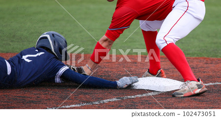 Third baseman tagging out runner who is head first sliding Third baseman tagging out runner who is head first sliding 102473051