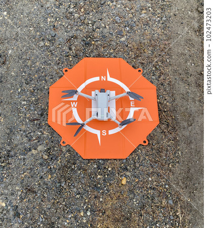 Drone quadcopter on a takeoff pad 102473203
