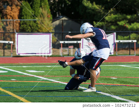 Football kicker kicking a field goal during a game Football kicker kicking a field goal during a game 102473212