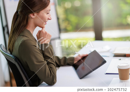 Concept of business office woman working,Businesswoman smile while working about her invesment plan with analyzing document and business investment graph data by using laptop on desk in workstation. Concept of business office woman working,Businesswoman smile while working about her invesment plan with analyzing document and business investment graph data by using laptop on desk in workstation. 102475732