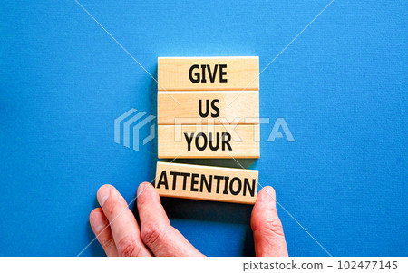 Give us your attention symbol. Concept words Give us your attention on wooden block. Beautiful blue table blue background. Motivational business give us your attention concept. Copy space. 102477145