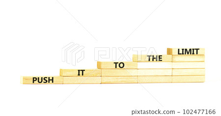 Push it to the limit symbol. Concept words Push it to the limit on wooden blocks. Beautiful white table white background. Business push it to the limit concept. Copy space. 102477166