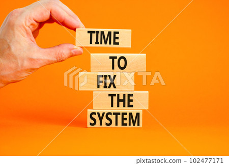 Time to fix the system symbol. Concept words Time to fix the system on wooden block. Beautiful orange table orange background. Businessman hand. Business and time to fix the system concept. Copy space 102477171