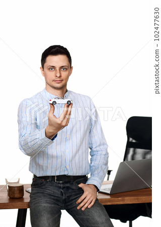 Successful caucasian businessman holding a toy car Successful caucasian businessman holding a toy car 102477630