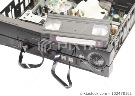 Retro disassembled video cassette recorders with broken VHS cassette with unwound tape isolated on white background 102478191