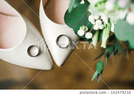 Beautiful toned picture with wedding rings and wedding shoes Beautiful toned picture with wedding rings and wedding shoes 102479238