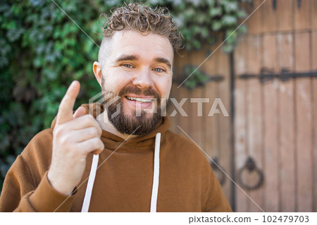 Handsome curly man takes a video of himself - video blog and youth blogger concept 102479703