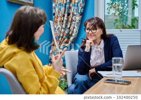 Woman social worker, mentor interviewing, talking to young female in office Woman social worker, mentor interviewing, talking to young female in office 102480250