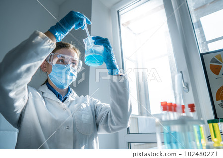 The photo depicts a scientist testing on instruments in a chemical laboratory to develop new methods for diagnosing and treating diseases. Medical professional performing a blood test The photo depicts a scientist testing on instruments in a chemical laboratory to develop new methods for diagnosing and treating diseases. Medical professional performing a blood test 102480271