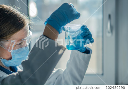 The photo shows a scientist in a biotechnological laboratory conducting research in the field of medicine and pharmaceuticals. Conducting tests in a chemical laboratory to diagnose diseases The photo shows a scientist in a biotechnological laboratory conducting research in the field of medicine and pharmaceuticals. Conducting tests in a chemical laboratory to diagnose diseases 102480290
