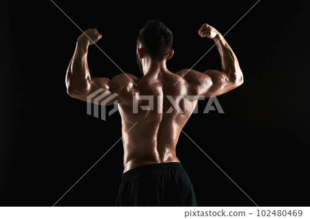 very muscular man posing with naked torso in studio 102480469