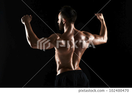very muscular man posing with naked torso in studio very muscular man posing with naked torso in studio 102480470