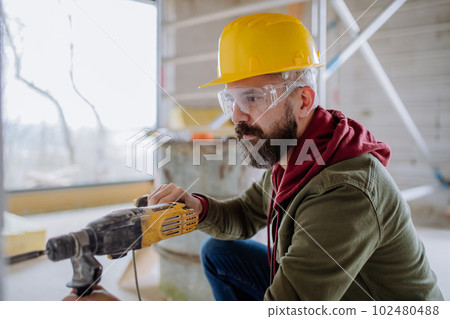 Portrait of mature man working in his unfinished house. 102480488