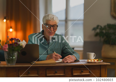 Senior man writing notes in his diary. 102480603