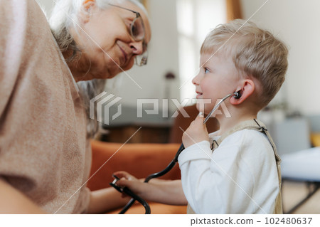 Little boy examining his grandmother, playing for doctor. Little boy examining his grandmother, playing for doctor. 102480637