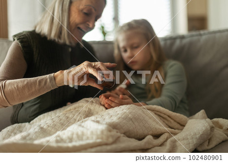 Senior woman taking care of her sick granddaughter. Senior woman taking care of her sick granddaughter. 102480901