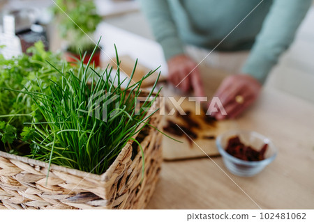 Close up of senior man cutting dried tomatoes. 102481062