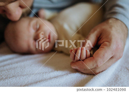 Close up of father holding hand of his newborn baby. 102481098