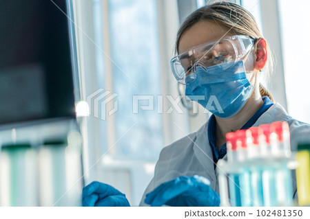 A medical scientist focuses on analyzing data on his computer to develop new drugs and therapeutic methods. A laboratory analyst is doing an experiment in a biotechnology laboratory and analyzing data 102481350