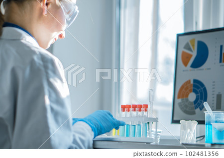 A medical laboratory assistant concentrates on analyzing the results of his work on computer in biotechnological laboratory. Chemist analyzes data in a pharmaceutical laboratory to develop new drugs 102481356