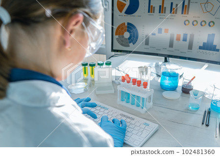 Doctor researcher analyzes results his experiments on a computer in chemical laboratory. Biotechnologist works concentrated at the computer, analyzing the results of research in a medical laboratory. Doctor researcher analyzes results his experiments on a computer in chemical laboratory. Biotechnologist works concentrated at the computer, analyzing the results of research in a medical laboratory. 102481360