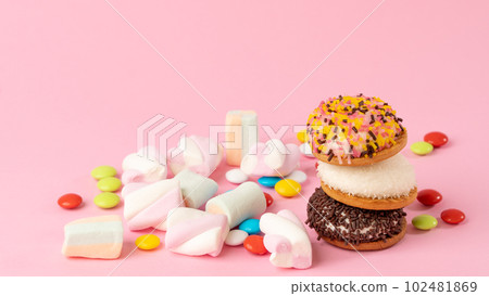 Sweets - cake, sweets, dragees, marshmallows on a pink background Sweets - cake, sweets, dragees, marshmallows on a pink background 102481869