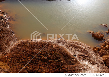 View of the clay shore near the reservoir, red-brown clay slides down to the water View of the clay shore near the reservoir, red-brown clay slides down to the water 102483242