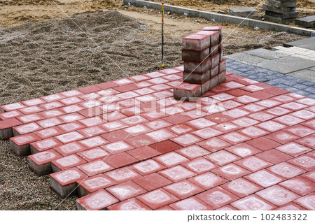 Fragment of an unfinished pavement construction site, paving stones and slabs of various colors 102483322