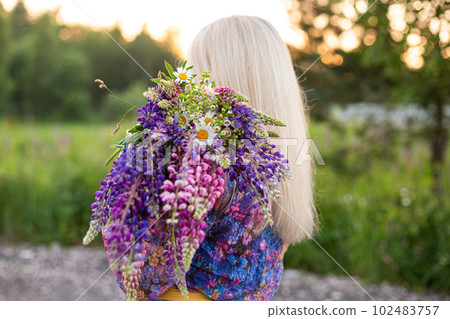 portrait of a girl in a blooming field in the sun at sunset 102483757